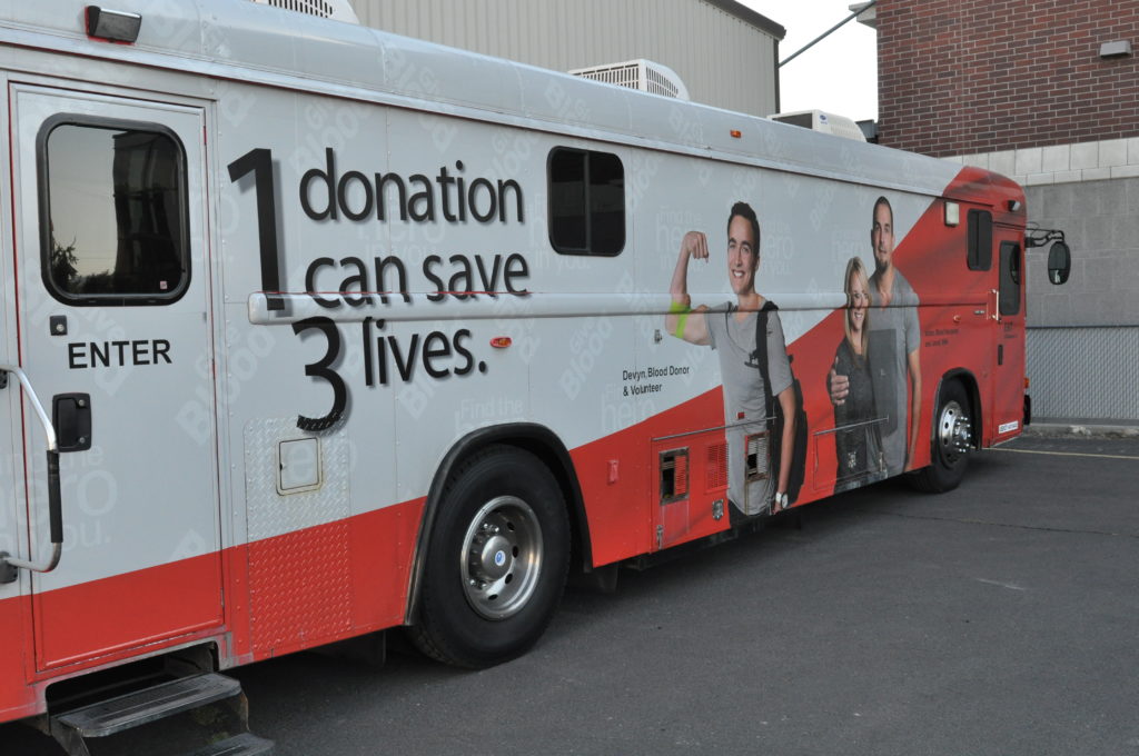 A bloodmobile, a large van with the words "1 donation can save 3 lives" written on the side.