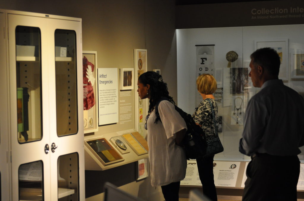 Three people inside a museum, observing the exhibits.