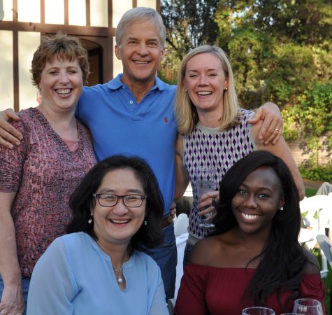 Five adults smile for the camera outside.