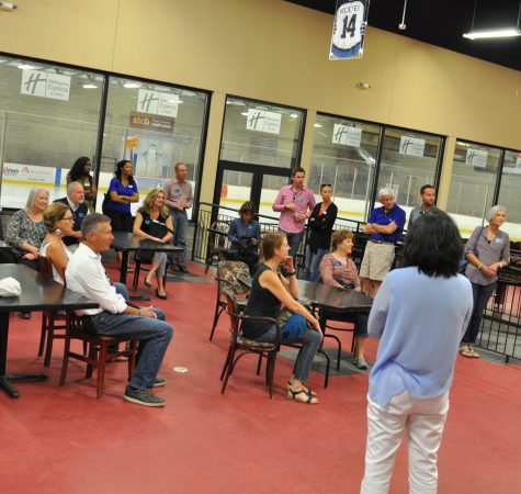 A group of adults inside the waiting room of an ice rink.