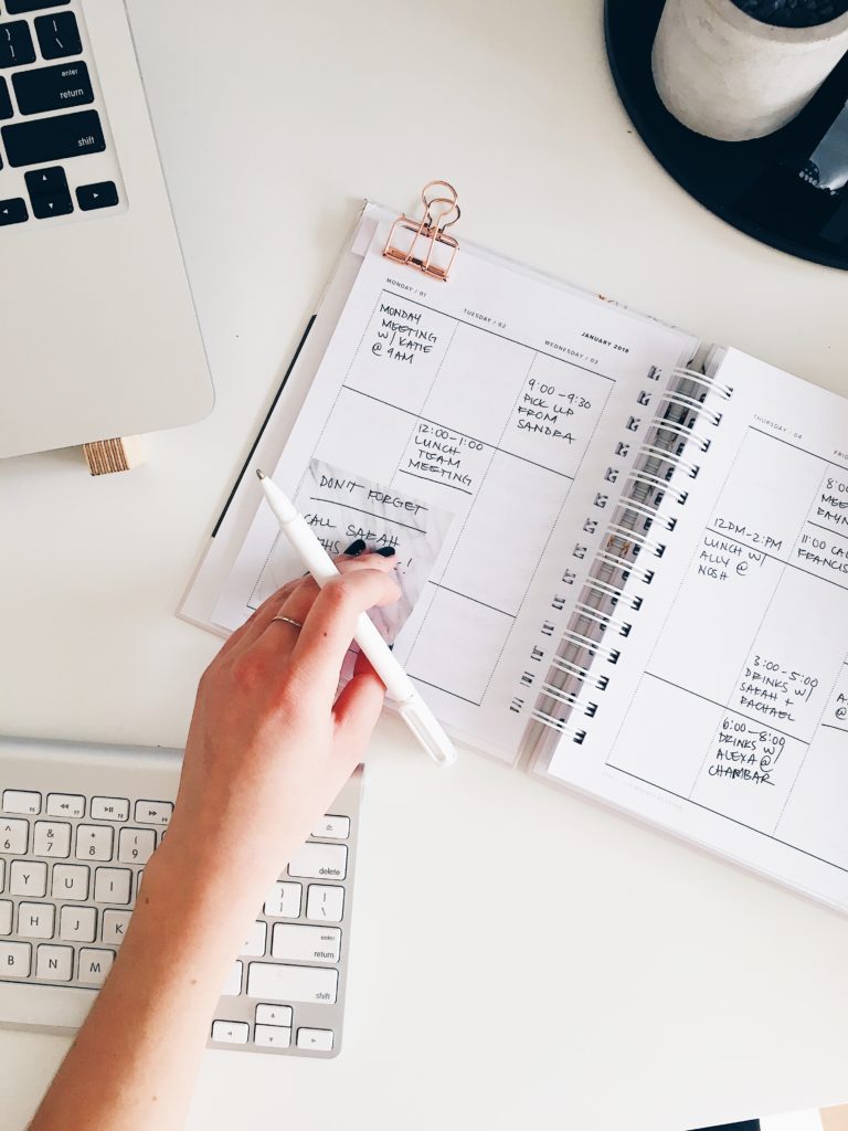 Overhead shot of someone's hand about to write in a planner