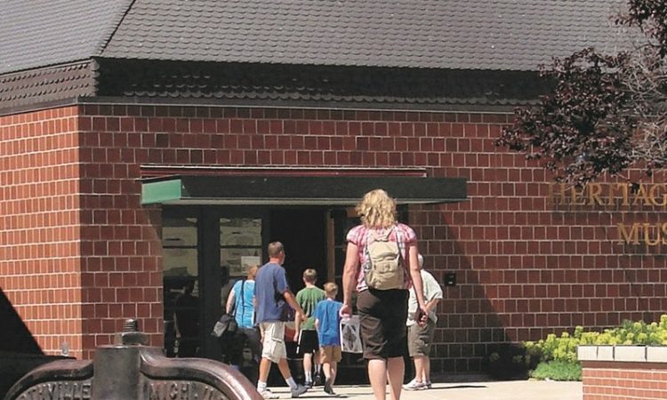 A brick building with children and adults walking into it.