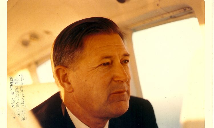 A man with straight dark hair looking away from the camera.