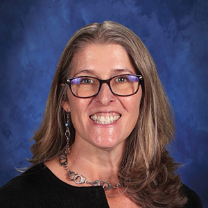 Elizabeth Beks, a woman with straight hair wearing glasses and a black shirt.