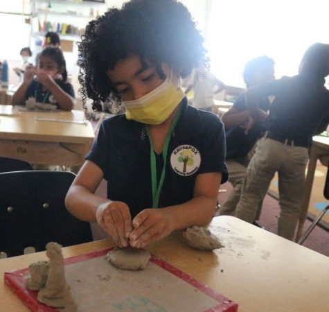 A young student plays with clay at KairosPDX.