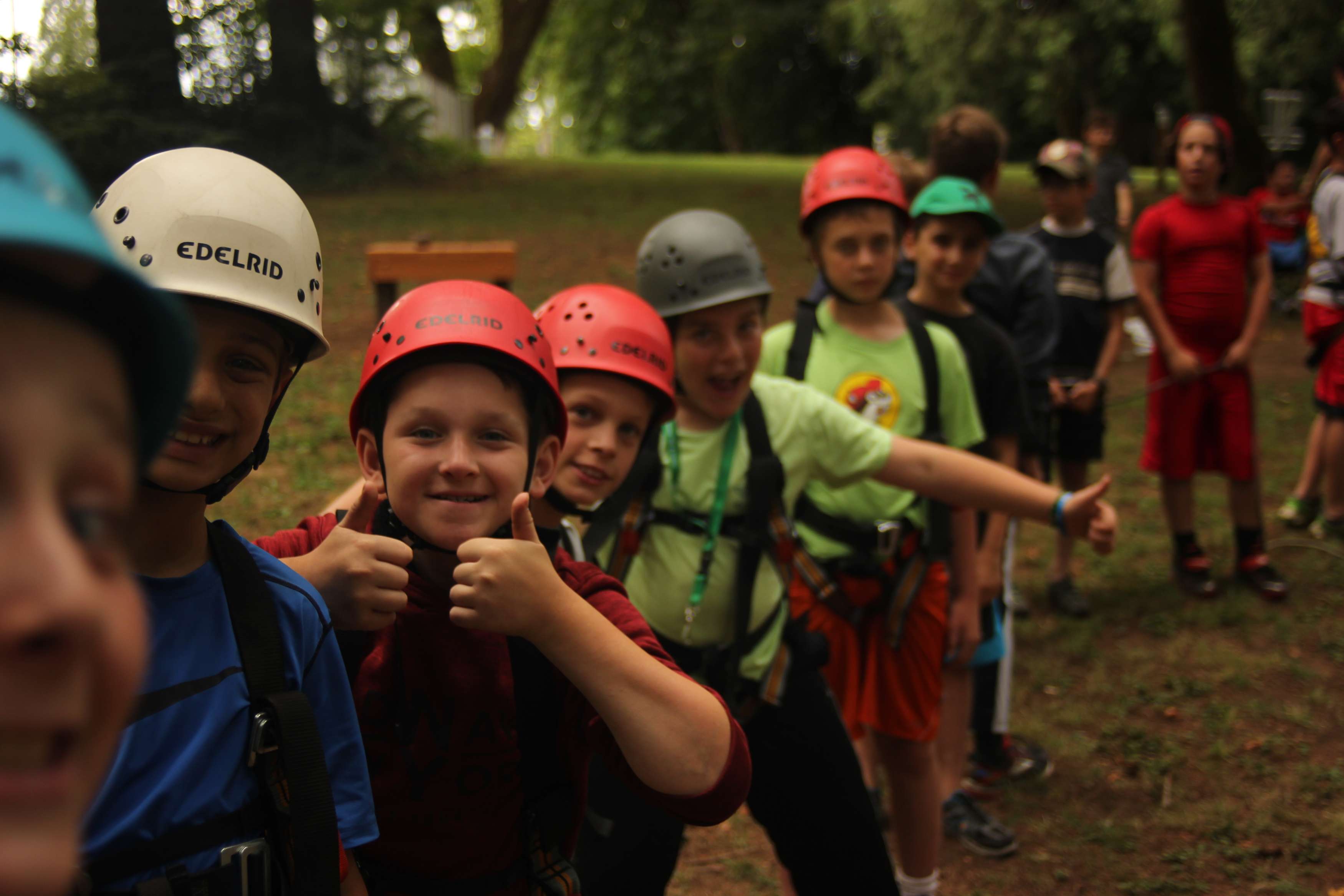 Group of kids in a line with smiles on their face and thumbs up