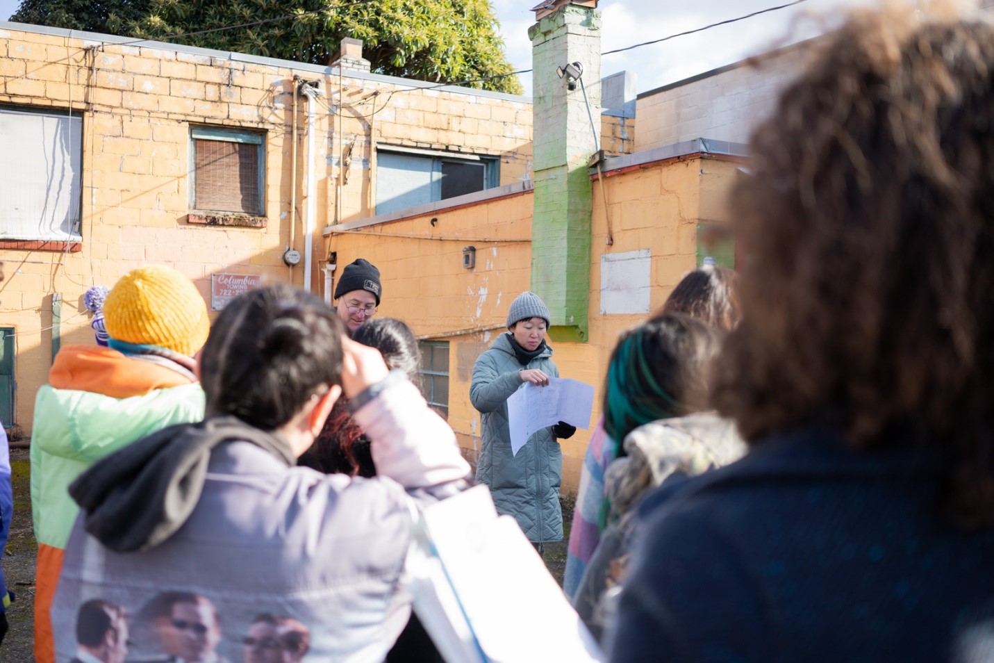 Woman reading off papers to a group of people touring museum